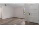 Open-concept space showcasing vinyl floors, a white door, and natural light at 3498 Plaza Ave, Spring Hill, FL 34608