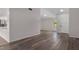 Open-concept living room featuring vinyl floors, a white front door, and a large window at 3498 Plaza Ave, Spring Hill, FL 34608
