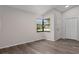 Bright living room features wood-look flooring, vaulted ceilings, and a corner window providing plenty of natural light at 3498 Plaza Ave, Spring Hill, FL 34608