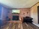 Wood look floors accent brick fireplace in this living room with desk, piano, and outside access at 4027 31St N Ave, St Petersburg, FL 33713