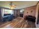 Spacious living room with wood flooring, brick accent wall, and comfortable workspace at 4027 31St N Ave, St Petersburg, FL 33713