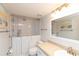 Bright bathroom featuring walk-in shower, light vanity, and beach-themed wall art at 4452 Garnet Dr # 302, New Port Richey, FL 34652