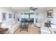 Bright living room with neutral tones, wood floors, and comfortable white furniture overlooking a dining area at 4452 Garnet Dr # 302, New Port Richey, FL 34652