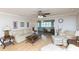 Inviting living room with comfortable white furniture and hardwood floors adjacent to a dining area at 4452 Garnet Dr # 302, New Port Richey, FL 34652