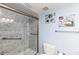 Walk-in shower featuring marble-look tile, grab bars, and glass enclosure at 4452 Garnet Dr # 302, New Port Richey, FL 34652