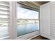 Bright water view framed by white shutters and window at 4452 Garnet Dr # 302, New Port Richey, FL 34652