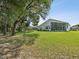 Expansive green backyard with a screened-in patio at 489 Tournament Dr, Spring Hill, FL 34608