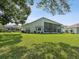 Expansive green backyard with a screened-in patio at 489 Tournament Dr, Spring Hill, FL 34608
