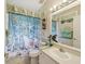 Bathroom with an ocean themed shower curtain, toilet, and sink at 489 Tournament Dr, Spring Hill, FL 34608
