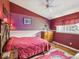 This bedroom features patterned wallpaper, red walls and carpet, and a wooden dresser and bedframe at 489 Tournament Dr, Spring Hill, FL 34608