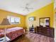 Cozy bedroom with wood floors, a ceiling fan, and a window providing natural light at 489 Tournament Dr, Spring Hill, FL 34608