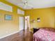Bright bedroom featuring yellow walls, wood floors, and a closet at 489 Tournament Dr, Spring Hill, FL 34608
