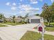 Exterior shot showing the 2 car garage, driveway, and landscaping at 489 Tournament Dr, Spring Hill, FL 34608