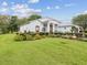 Charming single-story home featuring lush landscaping with flower beds at 489 Tournament Dr, Spring Hill, FL 34608