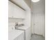 Bright laundry room features white cabinets, a white door, and a gray concrete floor at 489 Tournament Dr, Spring Hill, FL 34608