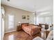 Bright main bedroom featuring wood floors, ceiling fan, sitting area, and a large window at 489 Tournament Dr, Spring Hill, FL 34608