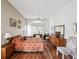 Spacious main bedroom featuring wood floors, ceiling fan, sitting area, and a large window for natural light at 489 Tournament Dr, Spring Hill, FL 34608