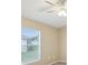A neutral bedroom with a ceiling fan and a view through a large window at 5048 Teather St, Spring Hill, FL 34608