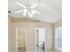 The room boasts a ceiling fan, neutral walls, and access to a walk-in closet and en-suite bathroom at 5048 Teather St, Spring Hill, FL 34608