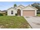 Charming single-story home featuring a neutral color scheme, attached garage, and well-manicured lawn at 5048 Teather St, Spring Hill, FL 34608