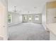 Bright, spacious living room with fresh carpet, a ceiling fan, and ample natural light through multiple windows at 5048 Teather St, Spring Hill, FL 34608