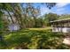 Large backyard with a shed, lush lawn, and ample space for outdoor activities at 5215 Azalea Cir, Dade City, FL 33523