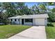 Charming home featuring a well-maintained lawn, a driveway, and a single-car garage at 5215 Azalea Cir, Dade City, FL 33523