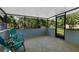 Relaxing screened-in patio with outdoor chairs and scenic views of the surrounding trees at 5215 Azalea Cir, Dade City, FL 33523