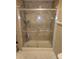 Bathroom featuring a glass-enclosed shower with safety bars and built-in shelving, offering a convenient bathing space at 5420 Bay Blvd, Port Richey, FL 34668