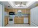 Galley kitchen with wood cabinets and white appliances at 5640 Ferguson Ct # 2203, New Port Richey, FL 34652