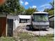 Exterior backyard featuring a vintage RV, shed, and fenced perimeter at 5748 Montana Ave, New Port Richey, FL 34652