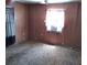 Bedroom featuring cheetah carpet, small window, and wood paneling at 5748 Montana Ave, New Port Richey, FL 34652