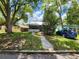 Quaint single-story home featuring a screened front porch and mature trees at 5748 Montana Ave, New Port Richey, FL 34652