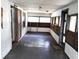 Enclosed front porch featuring gray wood floors, white walls, and multiple windows at 5748 Montana Ave, New Port Richey, FL 34652