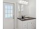 Bright bathroom features granite countertop, white cabinets, and door to the exterior at 5903 Cachette De Riviera Ct, New Port Richey, FL 34655