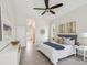 Bright main bedroom features gray and white decor, tile floor, ceiling fan, and doorway to the main bathroom at 5903 Cachette De Riviera Ct, New Port Richey, FL 34655