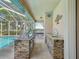 Covered outdoor kitchen with stone accents and stainless steel grill at 5903 Cachette De Riviera Ct, New Port Richey, FL 34655