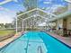 Screened-in pool with an outdoor kitchen and a view of the water at 5903 Cachette De Riviera Ct, New Port Richey, FL 34655