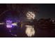Festive waterfront with lighted boat and fireworks reflection over the water at 5903 Cachette De Riviera Ct, New Port Richey, FL 34655