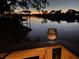 A calming waterfront at dusk featuring a glass of wine offering a lifestyle of relaxation and enjoyment at 5903 Cachette De Riviera Ct, New Port Richey, FL 34655