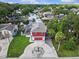 Stunning aerial view of the red home, canal, green lawn, and dock with boat access at 6241 Colony Cir, Weeki Wachee, FL 34607
