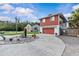 Inviting two-story home featuring a red facade, paved driveway, and landscaped circular garden at 6241 Colony Cir, Weeki Wachee, FL 34607