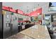 The kitchen is decorated with light fixtures and grey and black cabinets and stainless steel appliances at 6241 Colony Cir, Weeki Wachee, FL 34607
