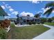 Backyard oasis featuring a screened-in pool area, complemented by lush landscaping for privacy and serene outdoor enjoyment at 6737 Clark St, Hudson, FL 34667