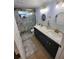 Updated bathroom featuring a double vanity, granite counters, and a tiled shower with a glass door at 6737 Clark St, Hudson, FL 34667