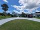 Inviting single-Gathering home with a long driveway, lush lawn, and tropical trees, perfect for a relaxed Florida lifestyle at 6737 Clark St, Hudson, FL 34667