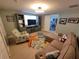 Cozy living room with a sectional sofa, patterned armchair, large TV and starfish rug at 6737 Clark St, Hudson, FL 34667