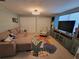 Inviting living room with a sectional sofa, patterned armchair, and a large TV, with beach themed decor at 6737 Clark St, Hudson, FL 34667