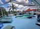 Screened-in pool area with lounge chairs and a sun umbrella, perfect for relaxation at 6737 Clark St, Hudson, FL 34667
