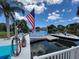 Picturesque waterfront view featuring a private dock, boat lift, and serene canal waters under a bright blue sky at 6737 Clark St, Hudson, FL 34667